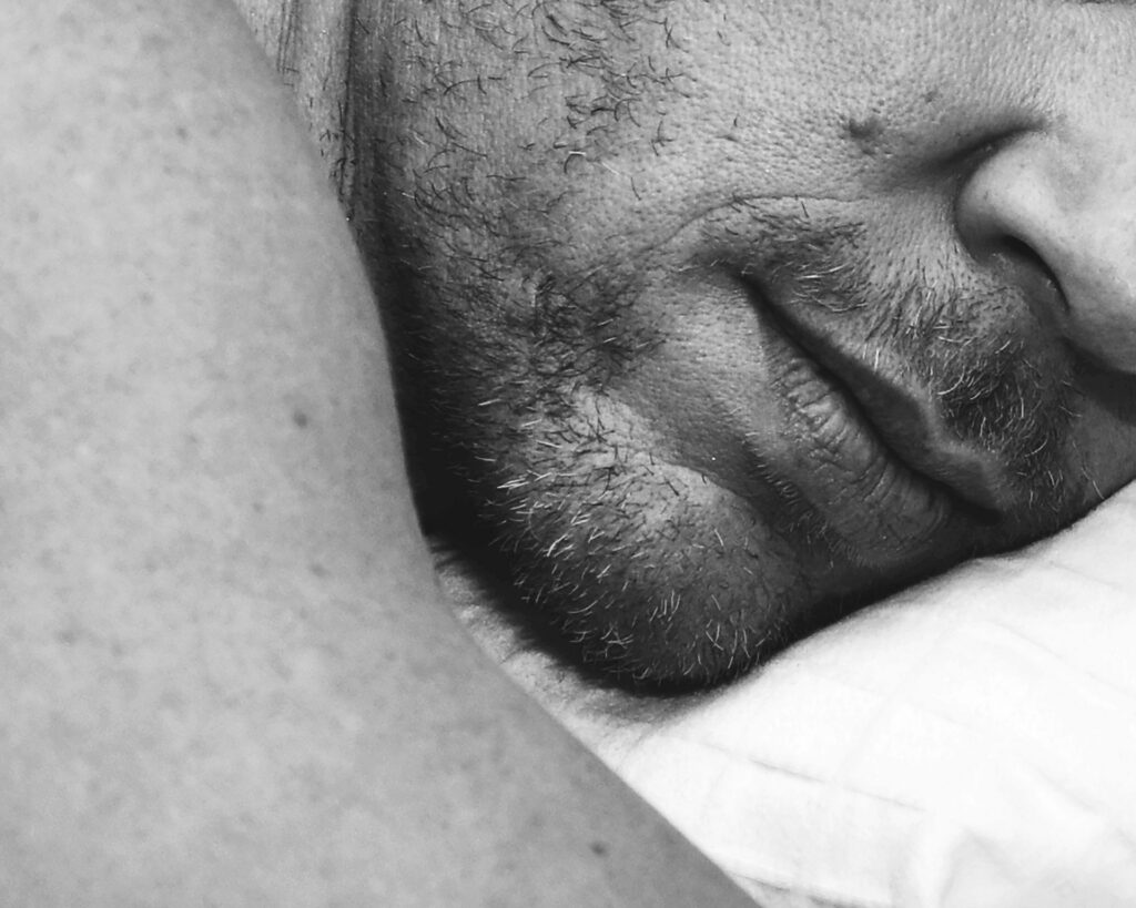 un homme dort sur le ventre, il risque d'avoir mal aux lombaires, aux cervicales et à la mâchoire